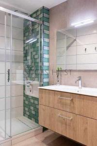 a bathroom with a sink and a glass shower at Sitges CENTRAL - En el corazón de Sitges in Sitges