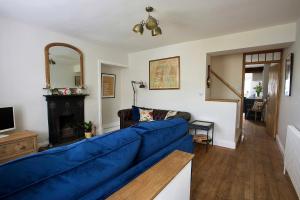 a living room with a blue couch and a fireplace at Fellfoot Cottage in the Lake District in Staveley