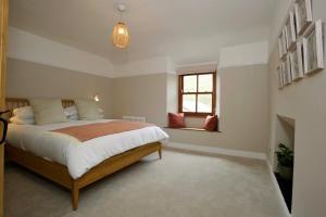 a bedroom with a large bed and a window at Fellfoot Cottage in the Lake District in Staveley