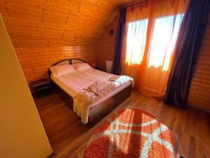 a bedroom with a bed in a wooden room at Cabana la Razvan in Petroşani