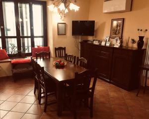 a dining room with a table with chairs and a television at B&B Mela in Rogiano Gravina