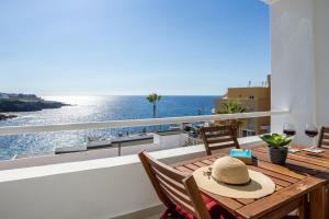 a table with a hat on a balcony with the ocean at The Blue Anchor SPECTACULAR SEA VIEW in Callao Salvaje