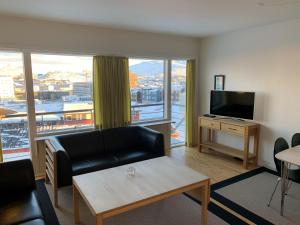 a living room with a couch and a flat screen tv at Nuuk Hotel Apartments by HHE in Nuuk