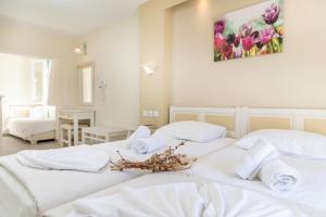 two white beds in a room with flowers on them at Villa Harmony in Agia Anna Naxos