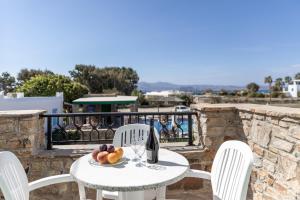 een tafel met een glas wijn en fruit erop bij Villa Harmony in Agia Anna Naxos