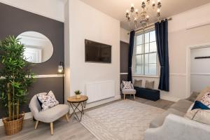 a living room with a couch and chairs and a tv at Host & Stay - The Seel Street Townhouse in Liverpool