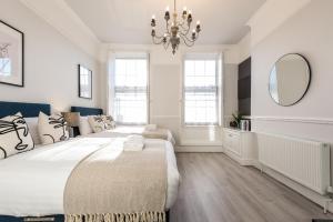 a white bedroom with a large bed and a chandelier at Host & Stay - The Seel Street Townhouse in Liverpool