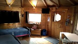 a bedroom with a bed in a wooden cabin at La Vallée du Cher in Monthou-sur-Cher