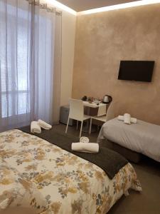 サンタニェッロにあるYourHome - Casa Aristideのベッドルーム1室(ベッド2台、テーブル、テレビ付)
