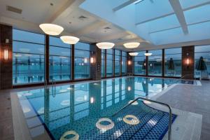 una gran piscina con ventanas de cristal y techo en Movenpick Hotel Malatya, en Malatya