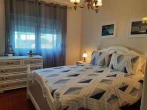 a bedroom with a bed and a dresser and a window at CASA DO NINHO - Entre o Campo e a Praia in Cadaval