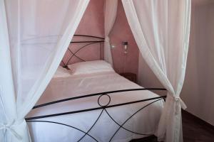 a bedroom with a canopy bed with white curtains at Fattoria L'Olmetto in Pisa