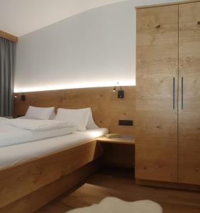 マトライ・イン・オストティロルにあるGästehaus Zedlacherhofのベッドルーム1室(大型ベッド1台、木製キャビネット付)