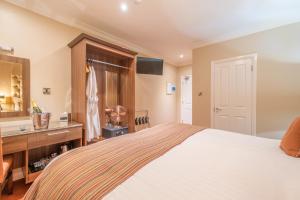 a bedroom with a bed and a vanity and a sink at Anchorage Inn in Portstewart