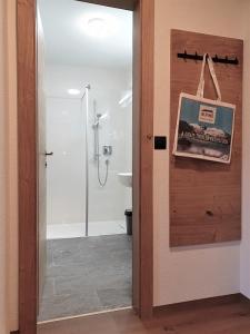 a bathroom with a shower and a toilet and a door at Gästehaus Zedlacherhof in Matrei in Osttirol