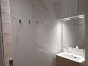 a white bathroom with a sink and a mirror at La Vigne d'Aubière 2 in Aubière