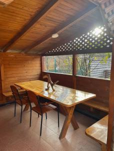 a wooden table and chairs in a room with a window at Yaremche House in Yaremche