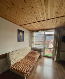 a bed in a room with a large window at Yaremche House in Yaremche