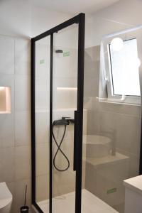 y baño con ducha y puerta de cristal. en Comfy Central Apartment, en Ioannina