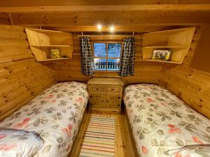 1 dormitorio con 2 camas en una cabaña de madera en Ferienhütte Bosic, en Baierdorf
