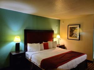 um quarto com uma cama grande e uma parede verde em Budget host inn em Salina