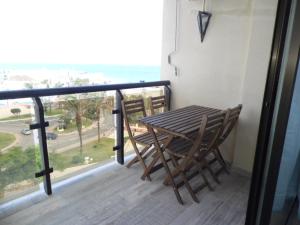 una mesa y sillas en un balcón con vistas al océano en Puerto Marina, en Benalmádena