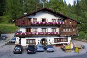 a large house with cars parked in front of it at Hotel Al Larin in Cortina dʼAmpezzo