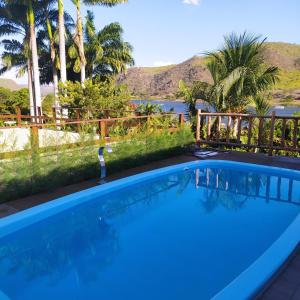 a blue swimming pool with a view of the water at Casa Temporada Waldemar Damasceno - Beira Rio com piscina in Piranhas