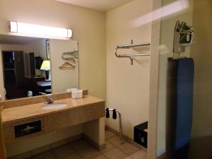 a bathroom with a sink and a mirror at Budget host inn in Salina