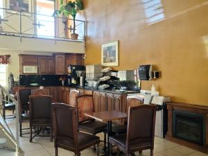 a kitchen with a bar with chairs and a table at Budget host inn in Salina