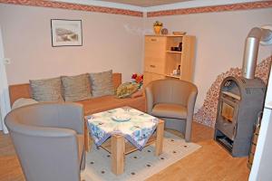 a living room with a table and a wood stove at Ferienhaus Fam_ Lemke in Bergen auf Rügen