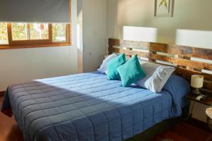 Un dormitorio con una gran cama azul con almohadas azules en Hostal Aldea Colchagua Experience, en Santa Cruz