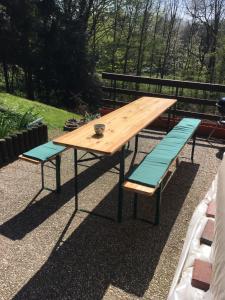a picnic table and benches with a view of trees at Ferienwohnung Sandner in Porta Westfalica