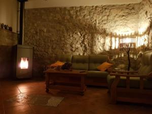 a living room with a green couch and a stone wall at PietraViva Casa vacanze FAICCHIO, NON VISANTI in Visanti +14 photos