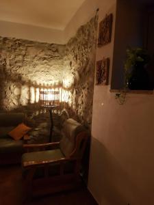 - un salon avec un canapé et un mur en pierre dans l'établissement PietraViva Casa vacanze FAICCHIO, NON VISANTI, à Visanti
