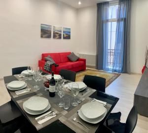 a dining room with a table and a red couch at Casa Milena in Mestre