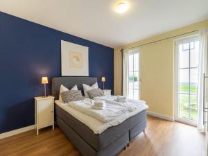 a bedroom with a large bed with a blue wall at Pretty Holiday Home in Bastorf with Private Garden in Bastorf