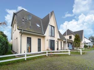 a white house with a black roof at Pretty Holiday Home in Bastorf with Private Garden in Bastorf