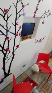 een woonkamer met een muurschildering van bomen op de muur bij B&B del Corso in Crispiano