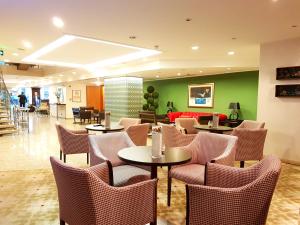 a restaurant with tables and chairs and a couch at Jura Hotels Mavi Sürmeli Adana in Adana