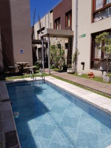 a swimming pool in front of a building at Taruca Apart in Salta