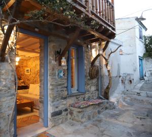 een stenen cottage met een deur en een veranda bij Villea Seaview Apartments in Skopelos Town