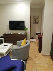 Una sala de estar con un sofá y un televisor. en Nuzul Altoot Apartments نزل التوت, en Riad