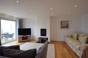 a living room with a couch and a flat screen tv at Halcyon - 4 Bed Luxury Holiday home in Salcombe (Sleeps 8) in Salcombe