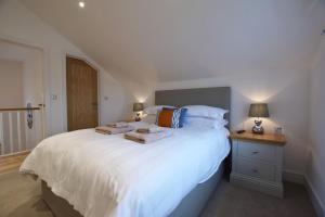 a bedroom with a large white bed with towels on it at Halcyon - 4 Bed Luxury Holiday home in Salcombe (Sleeps 8) in Salcombe