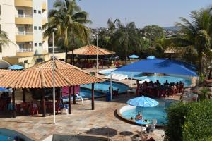 a view of a pool with umbrellas and people at a resort at Suíte Thermas Place in Caldas Novas