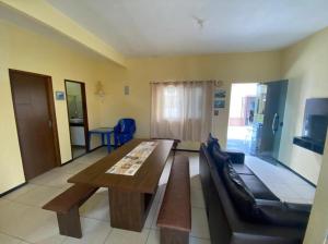 ein Wohnzimmer mit einem Holztisch und einer Couch in der Unterkunft Casa de Praia Atalaia in Salinópolis