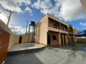 ein Gebäude mit einem leeren Parkplatz davor in der Unterkunft Casa de Praia Atalaia in Salinópolis