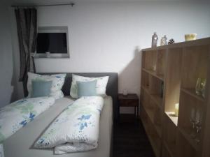 a bedroom with two beds with pillows and a television at Moderne Ferienwohnung bis 4 Personen in Ronneburg