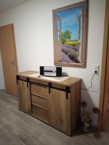 a desk with a window and a picture on the wall at Moderne Ferienwohnung bis 4 Personen in Ronneburg